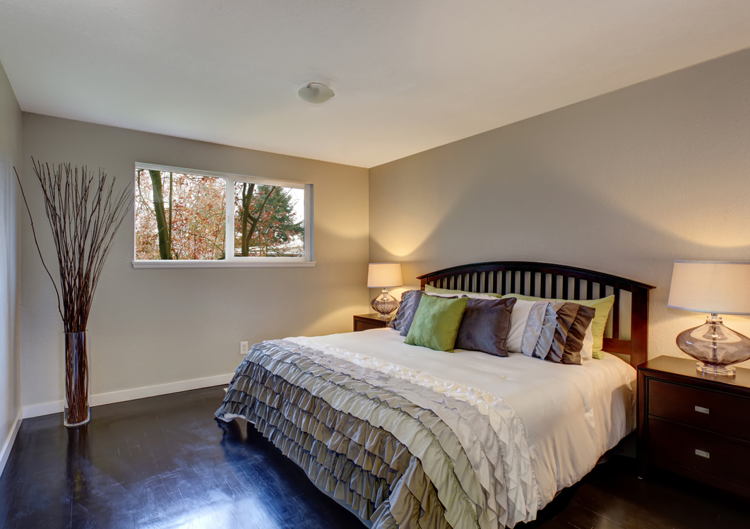 Perfect hardwood bedroom with ruffled bedding.